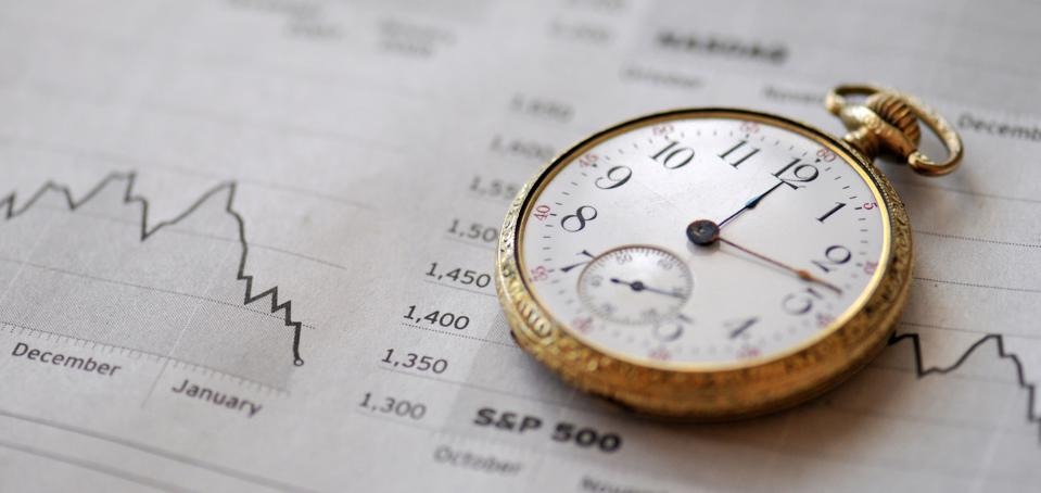 Financial Timing Timing in the financial markets and in business. An old pocket watch and charts from the business section of a newspaper